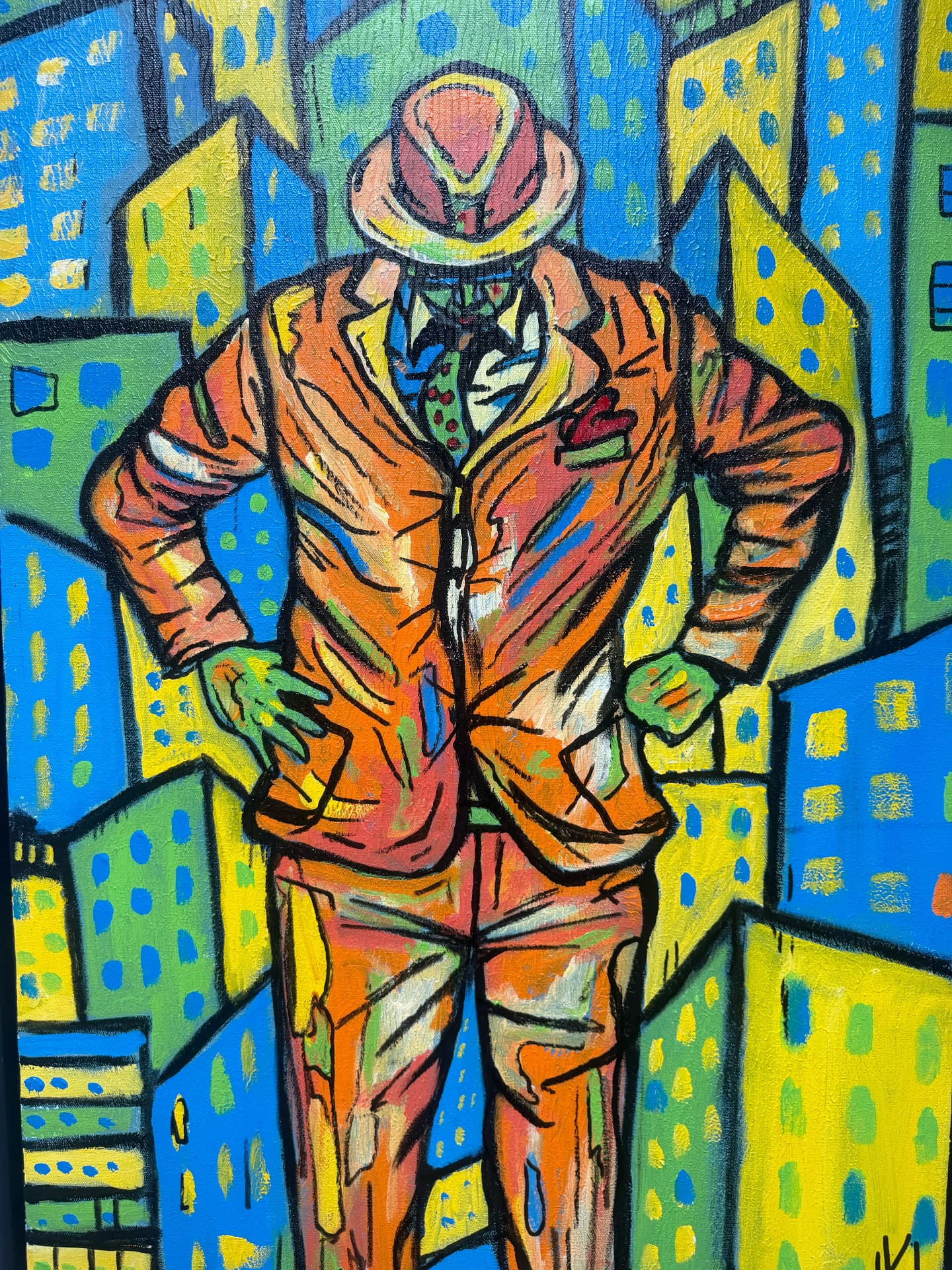 Man in an orange suit and hat standing among city buildings