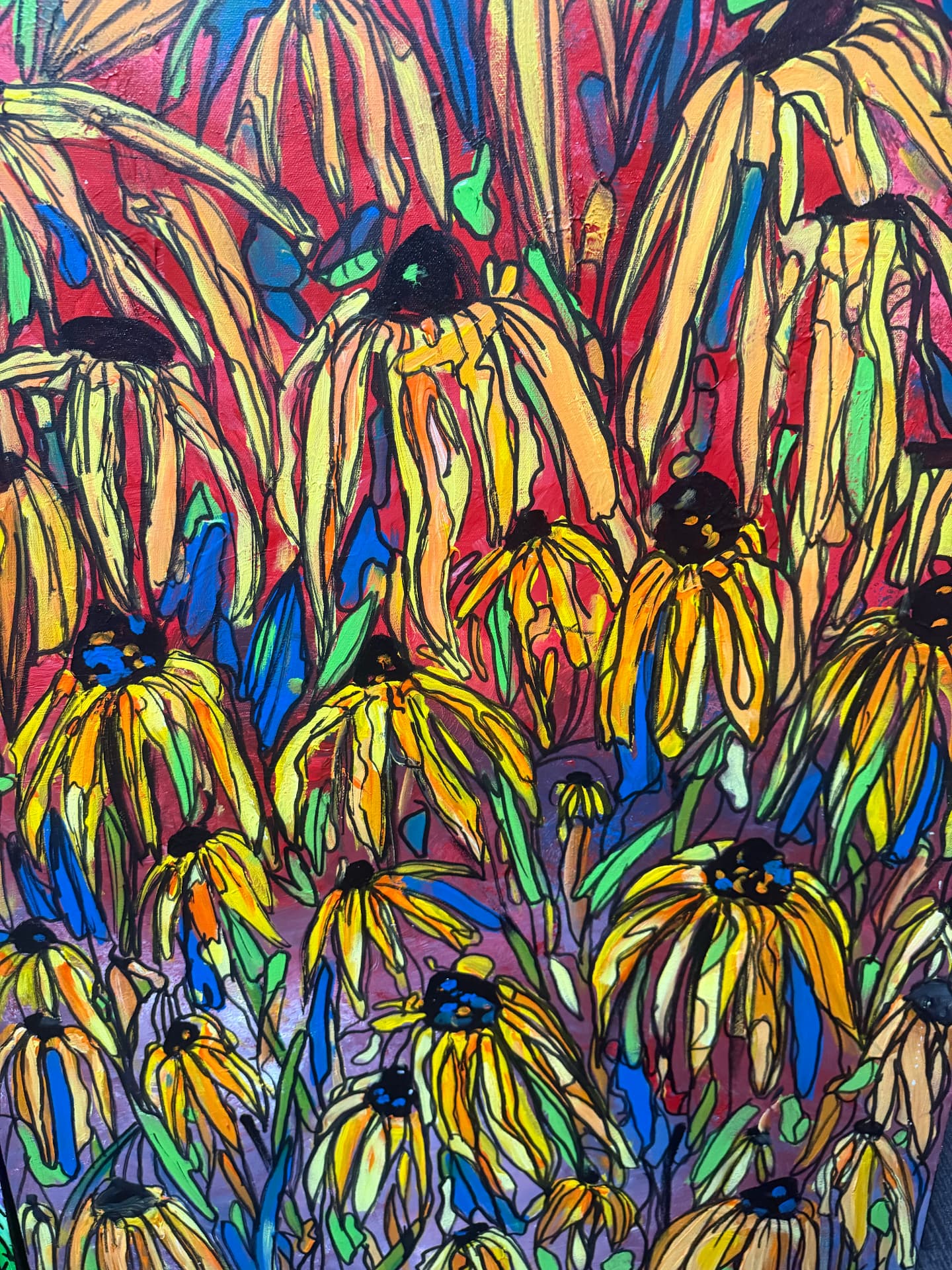 Yellow coneflowers with dark seed heads against red, blue and green